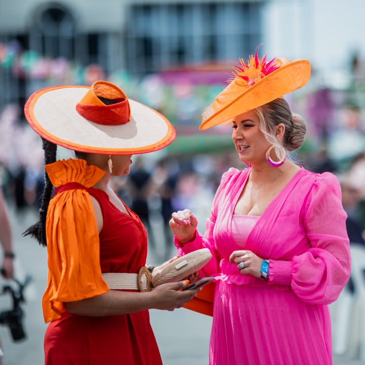 Two well dressed women talking to each other and enjoying the Harness Life event and races