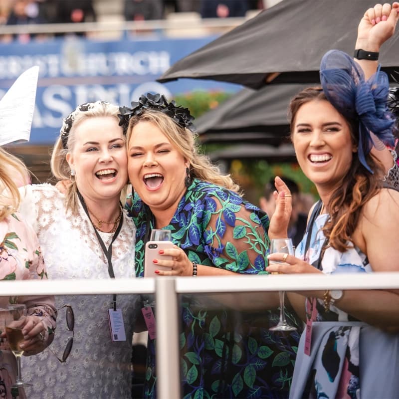 A group of well dressed female friends drinking and enjoying the Cup day at Harness life event