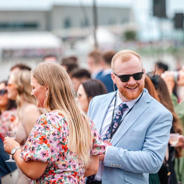 A well dressed couple enjoying the Harness races event